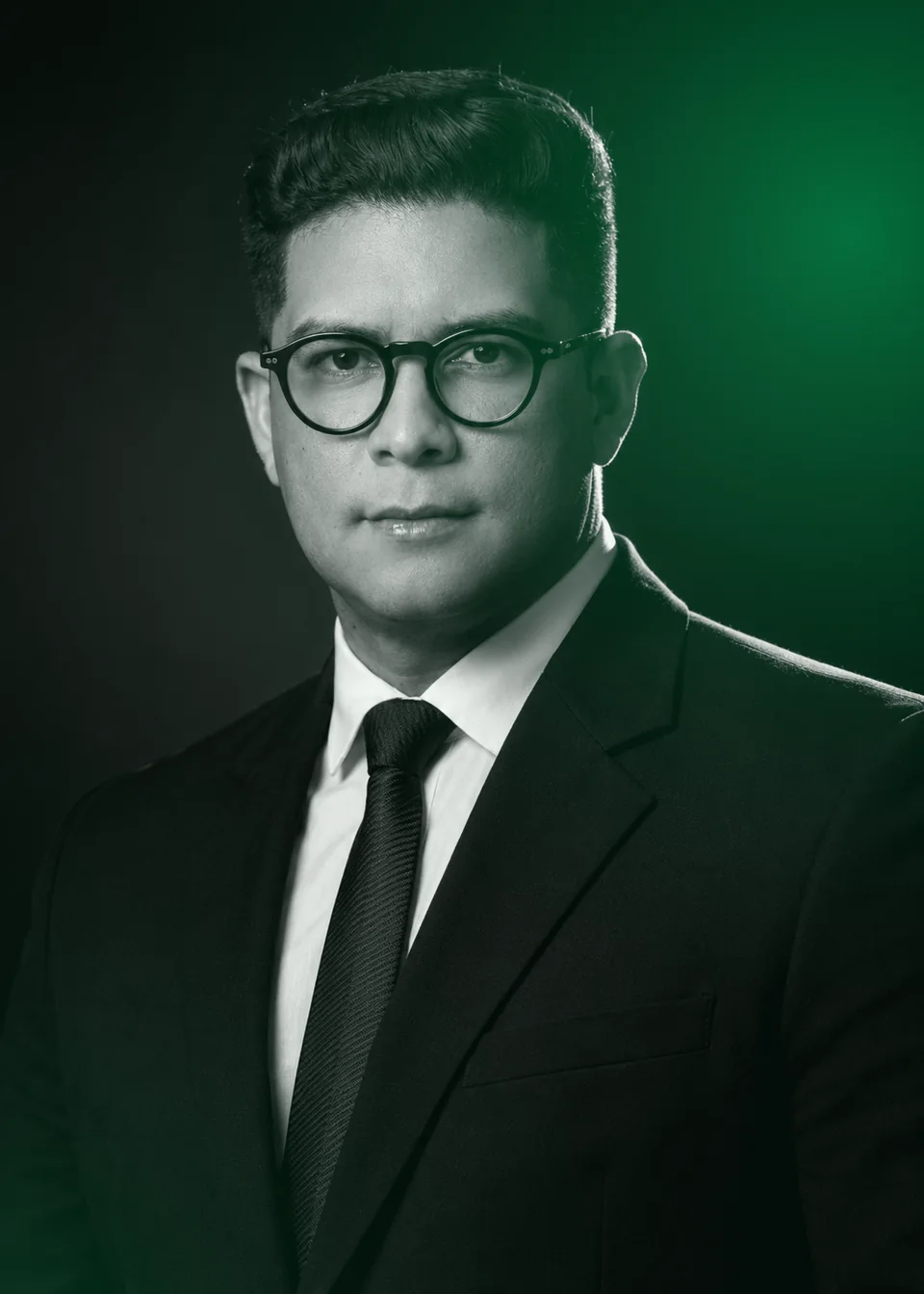 Retrato em preto e branco de Anthony Linares, com luz verde ao fundo.